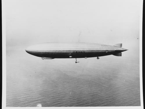 An airship is seen flying above the ocean.