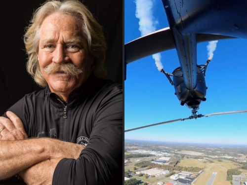 Portrait of a Chuck Aaron alongside a helicopter being piloted upside down