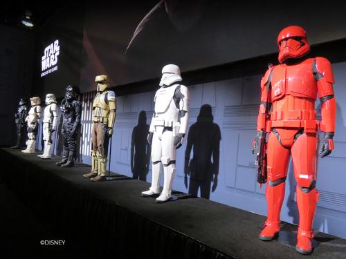 Seven Star Wars Stormtrooper costumes on a display platform.