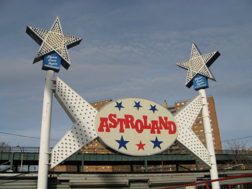 Large white sign reading Astroland in red letters covered in light bulbs.