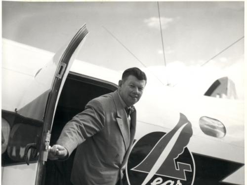 A man stepping out of the door of a small aircraft that says "lear" on its side.