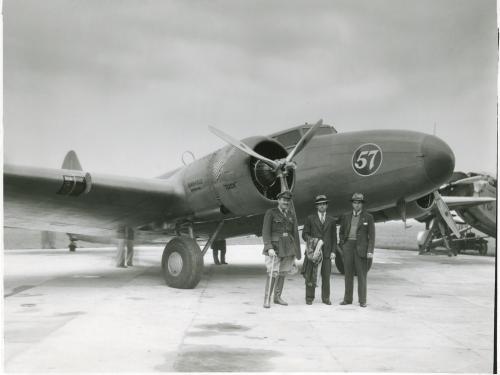 One-half right front view of the Boeing 247D with three men posing in front.