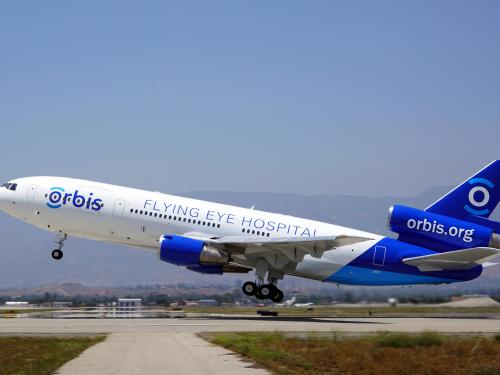 A plane taking off that reads "Orbis, Flying Eye Hospital, orbis.org" on the side. 