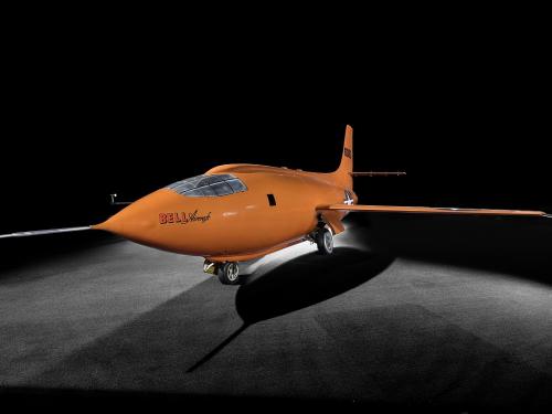 Bell X-1 aircraft photographed from a side angle against a dark backdrop