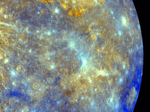 An image showing a half circle view of Mercury's surface in purples and yellows. 