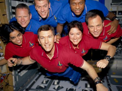 A crew of seven astronauts floating in zero garvity.