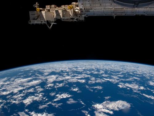 Earth viewed from above with part of the ISS in the upper part of the photo.