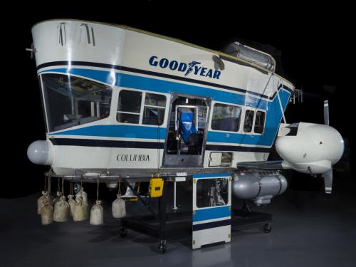 A control car for a blimp, this is painted blue and white and has the Goodyear logo on the side.