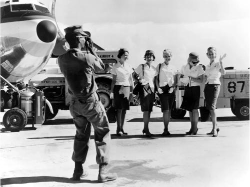 A US military member photographs a group of flight attendants 