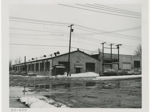 Exterior of a one-story industrial building with a wet, snowy parking lot in the foreground