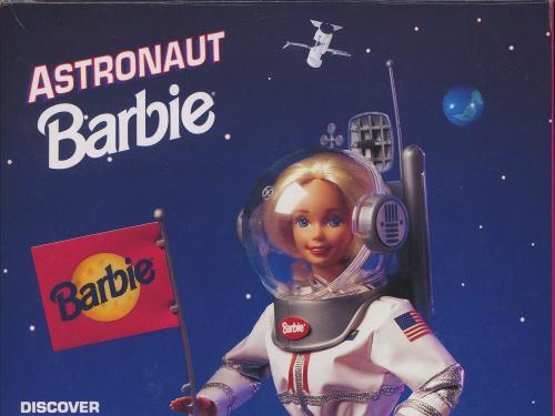 The back of the box that 1994 Astronaut Barbie was sold in. It depicts Barbie walking on the Moon while wearing a white spacesuit and planting a Barbie flag into the ground.