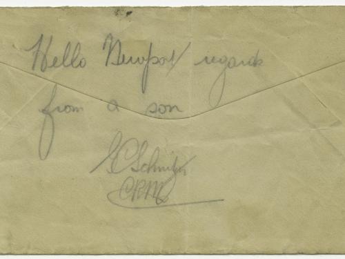 The back of a weathered envelope that has the words "hello newport / regards from a son" and George Schnitzer's signature written on it.