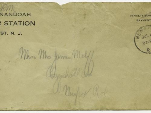 A weathered addressed envelope with a stamp in the upper righthand corner and the words USS Shenandoah, Naval Air Station, Lakehurst, N.J. in the upper lefthand corner.