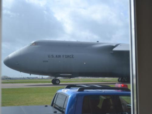 Closeup of a large aircraft as it taxis on a runway.