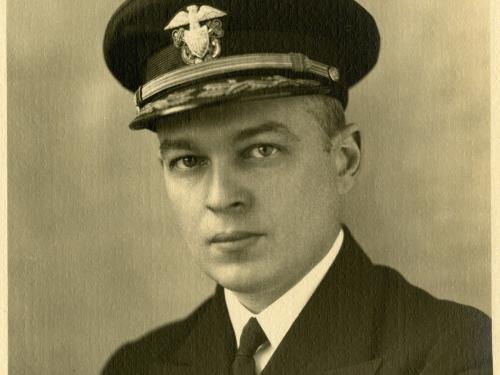 Portrait of a man in military uniform with arms folded.