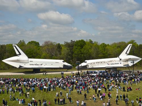 The Space Shuttles Enterprise and Discovery are placed side by side on the tarmac near the Udvar-Hazy Center.