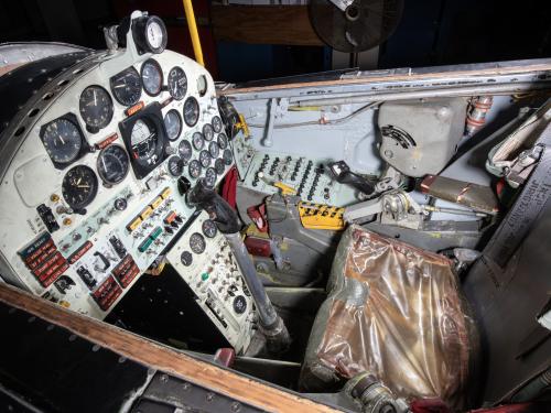 Detailed view of the cockpit of a vintage aircraft, featuring an array of dials, switches, and controls.