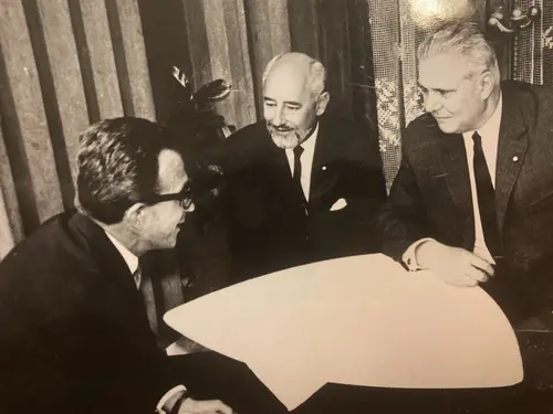 Vintage image of three men sitting by a table having a discussion.