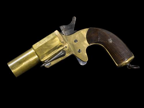 Side view of a yellow painted flare pistol.