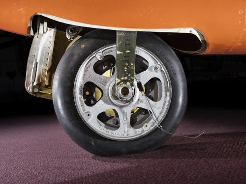  View of a tire on an aircraft. The aircraft is painted orange. 