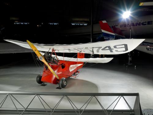 Red and white open-cockpit staggered wing aircraft 