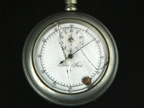 Broken stopwatch with hand pointed at nine-minute mark. 