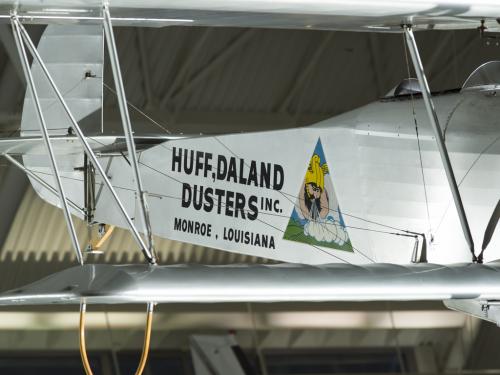 Silver painted fuselage of a biplane. Huff-Daland Duster is painted on the side of the plane.