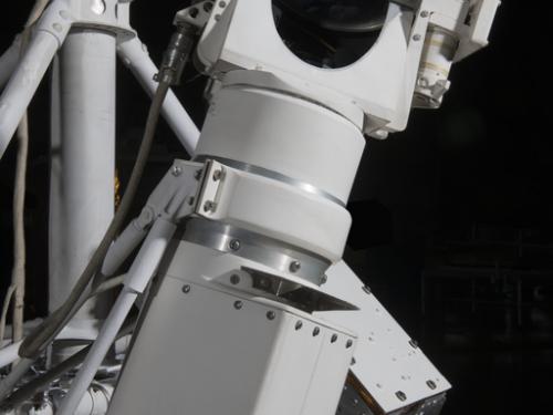 White painted tv camera and lens attached to a spacecraft. 