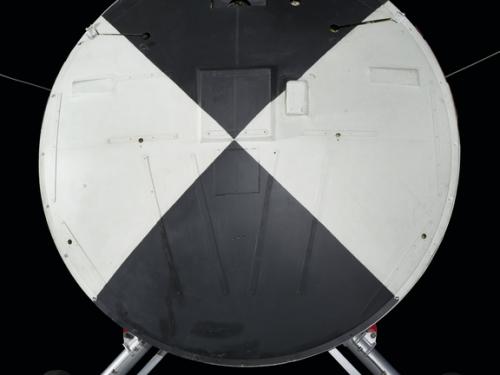 Painted black and white heatshield with wheels attached to the vehicle. 