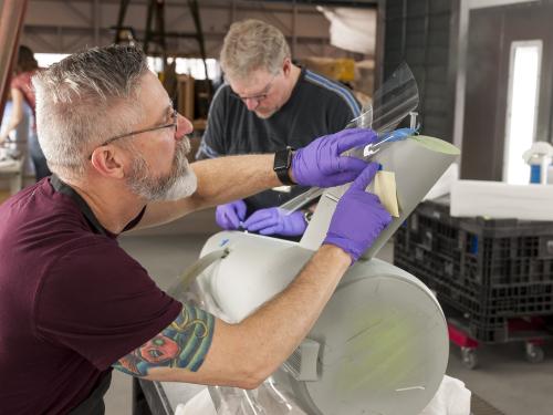 Bill George marks windows on the secondary hull of the Enterprise model. 