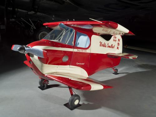 Side view of a red and white painted smallest man-carrying plane.