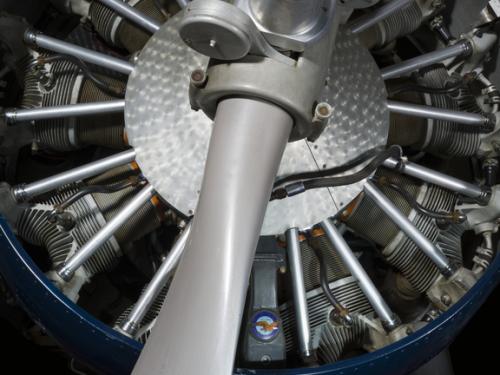 Close up view of a propeller attached to an engine of a plane.