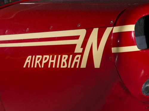 Logo of a plane called Airphibian. The plane is painted red and the logo is painted tan.