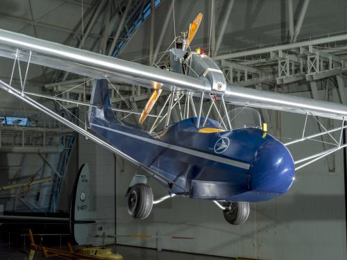 2-place parasol-wing silver and blue monoplane with 45hp Szekely SR-3 Cylinder Model O pusher engine.