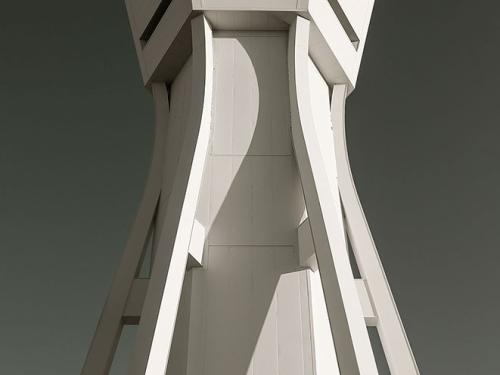 An air traffic control tower with light-colored, contemporary style supports. Near the top, a base for operations has at least three sides for different perspectives of observation.