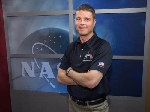 Reid Wiseman, a white male NASA astronaut, poses informally with his arms crossed.