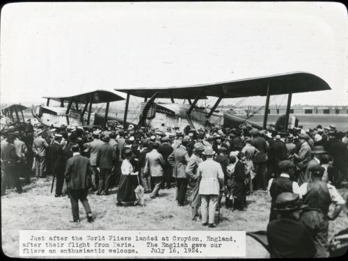 A large group of people view two Douglas World Cruisers, aircraft which were the first to travel around the world, in England.