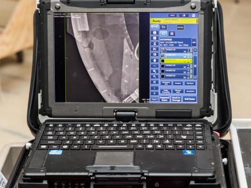 A laptop features an X-ray scan of part of a dish-shaped spaceship studio model.