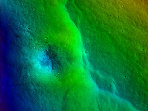 Colored topographic map of a portion of the Moon with a fault scarp visible as a line of dark greens (higher elevations) correspond with an immediate dip into lower elevations (highlighted in lighter greens).