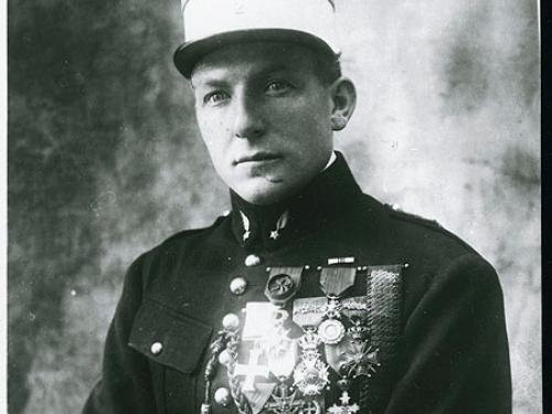 Portrait of Charles Nungesser, a French World War I pilot, as he sits wearing his military uniform with military decorations on his right chest.