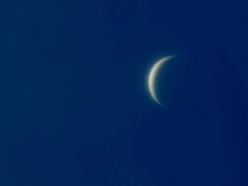 Daytime view of Venus, which is seen as a crescent shape.