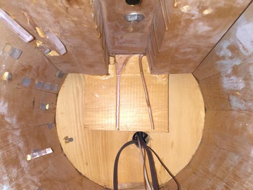 Top view of the interior of the vertical hull section of a spaceship studio model from the show Star Trek. The hull is made from light brown colored wood and plexiglass.