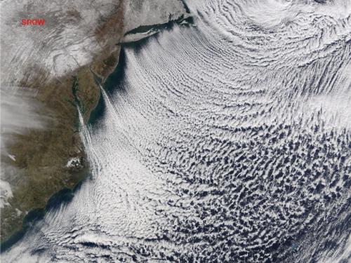 Satellite view of a group of cloud formations that look like organized rows of clouds.