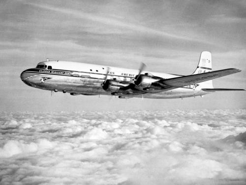 Side view of commercial aircraft in flight. Aircraft features four engines and Pan American Airways livery.