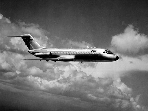 Side view of commercial jet aircraft in flight. The jet features Trans-Texas Airlines livery and has two engines placed near the rear of the fuselage.