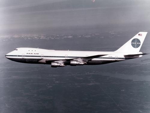 Black and white colored side view of aircraft with four engines and Pan Am Airways livery. Aircraft is in flight.