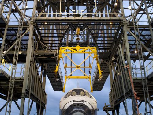 The Space Shuttle Discovery is placed under a securing device known as a mate-demate device prior to its arrival to the Udvar-Hazy Center.