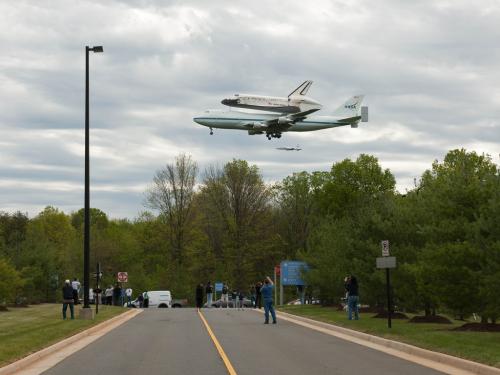 Space Shuttle Discovery prior to landing at Washington Dulles International Airport. It is flying low, so spectators get a good look at the shuttle and the shuttle transport aircraft.