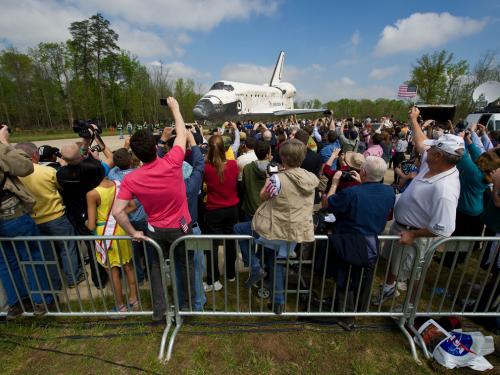 Spectators watch as the Space Shuttle Discovery is rolled towards the Udvar-Hazy Center.