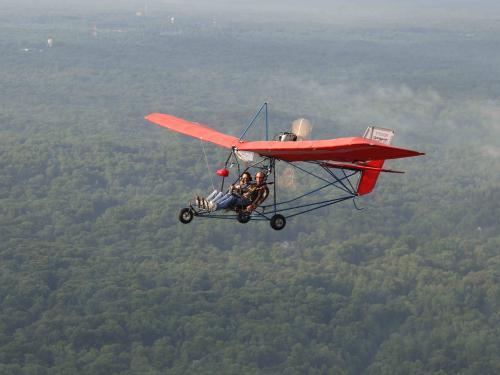 Red-winged ultralight aircraft with seating for two people.